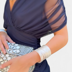 Long dark blue dress with draped bodice and sheer mesh sleeve overlay