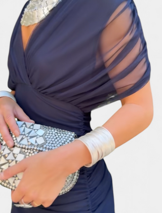 Long dark blue dress with draped bodice and sheer mesh sleeve overlay