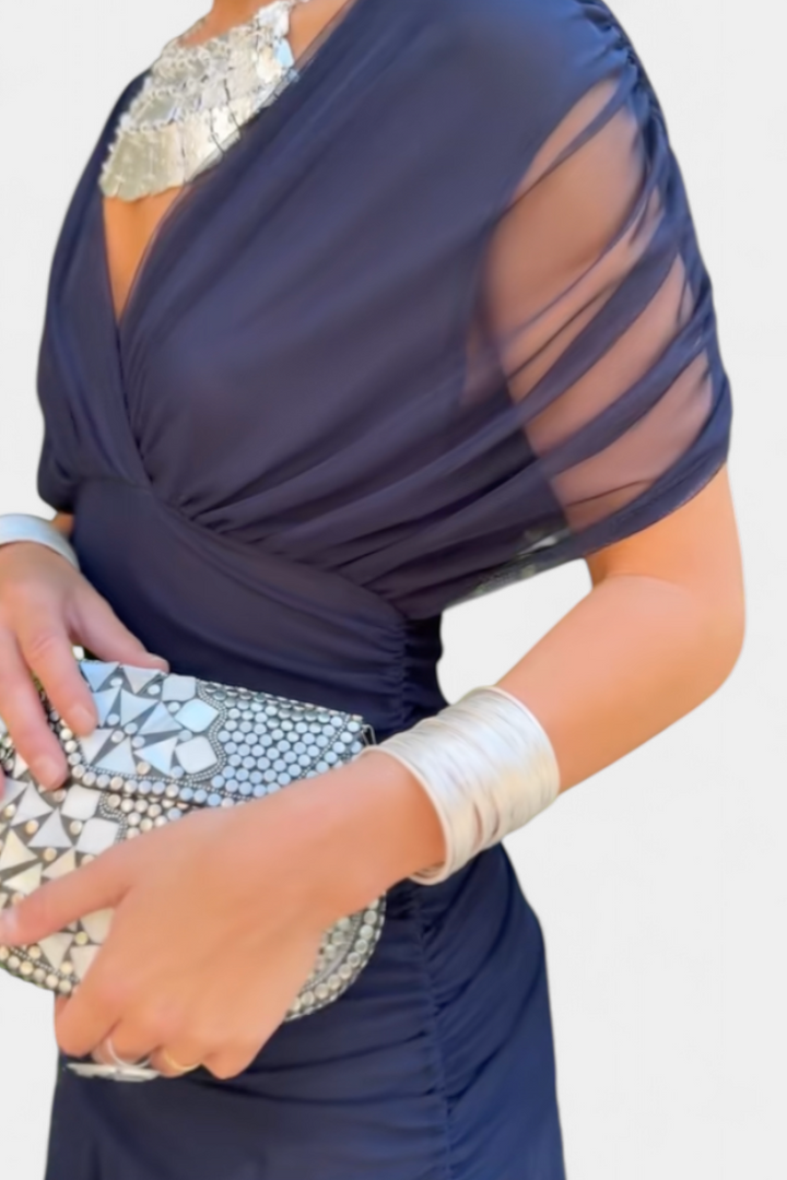 Long dark blue dress with draped bodice and sheer mesh sleeve overlay