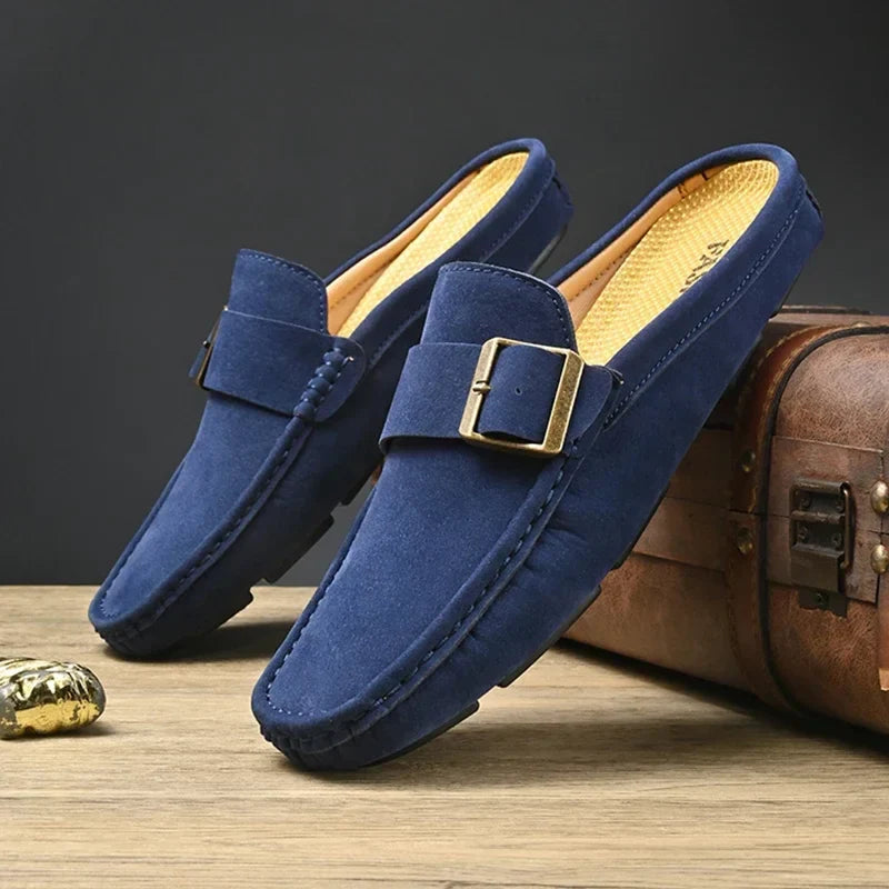 Pair of blue suede mules with square buckle strap and stitched moccasin edge