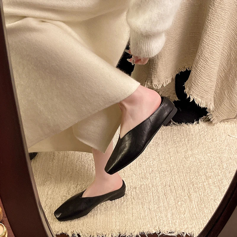 Black pointed-toe low-heel mules with slip-on backless design.