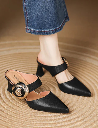 Black genuine leather heels with pointed toe, ankle strap, and gold rosette buckle detail