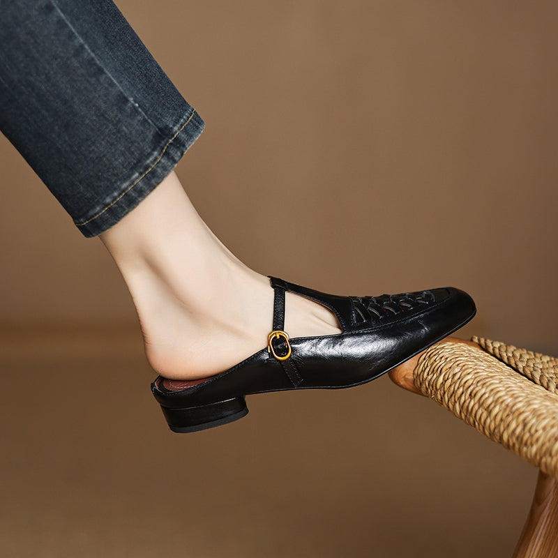Black leather mule with lace-up front and round strap detail at the vamp