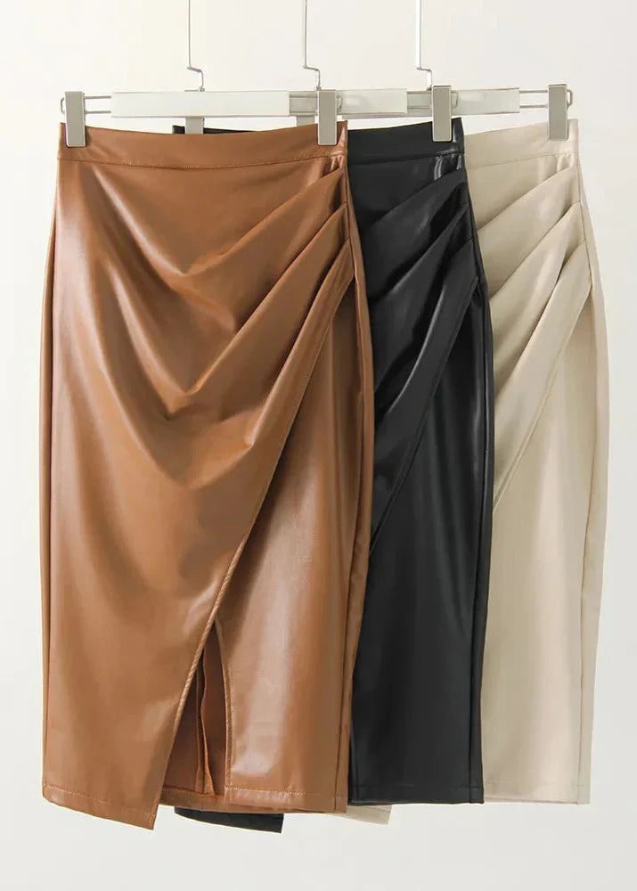Set of three leather midi skirts on hangers: tan, black, and cream