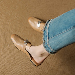 Tan leather mule with square-toe, slip-on design, and metallic buckle strap