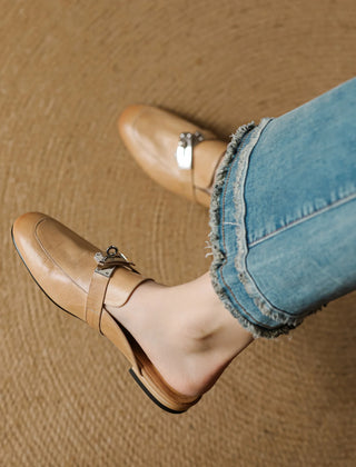 Tan leather mule with square-toe, slip-on design, and metallic buckle strap