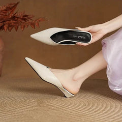 Beige leather mules held up, pointed toe and low heel slip-on