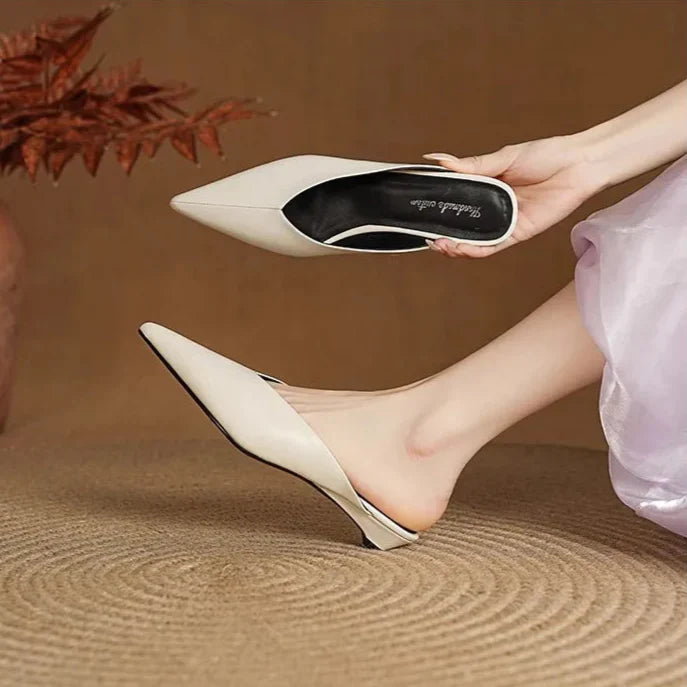 Beige leather mules held up, pointed toe and low heel slip-on