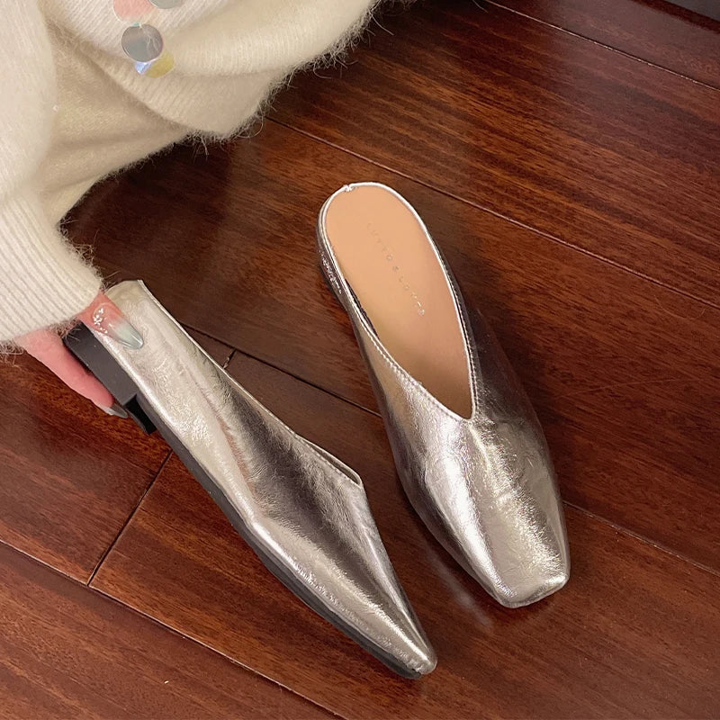 Silver metallic mules with pointed toe and low block heel, slip-on style