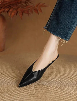 Black leather pointed-toe mules with low heel, slip-on style.
