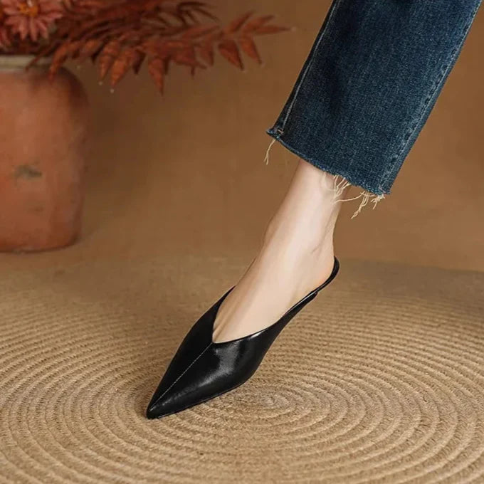 Black leather pointed-toe mules with low heel, slip-on style.