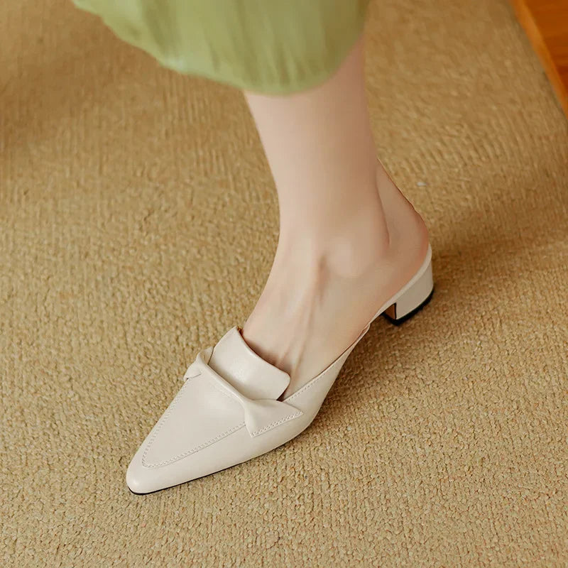 Beige leather mule shoes with pointed toe and low block heel, front angle