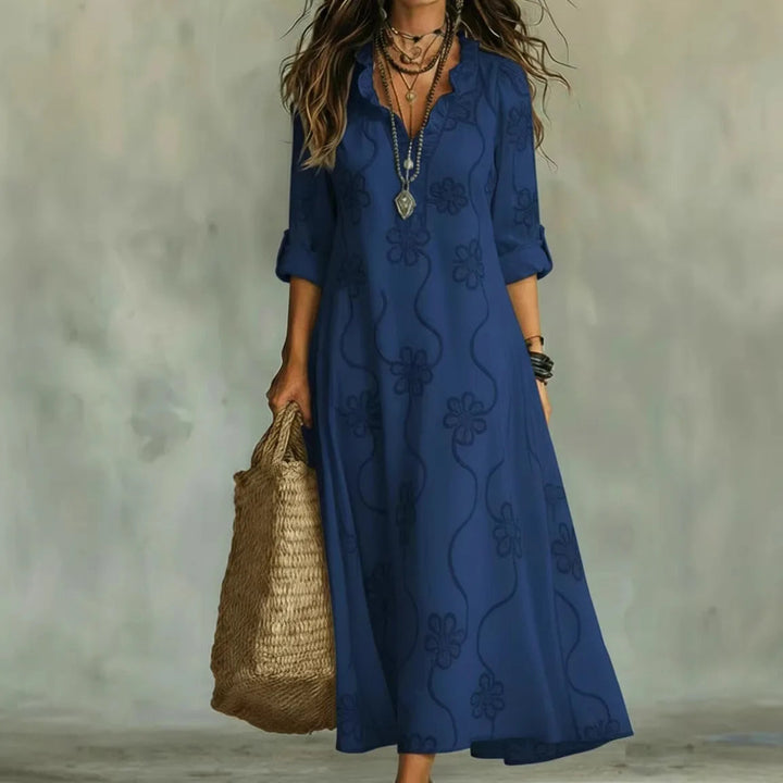 Blue maxi dress with short sleeves and subtle floral pattern, V-neck.