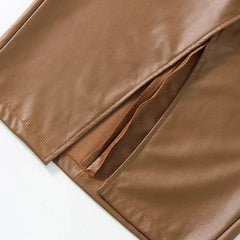 Close-up of brown leather skirt hem with stitching and narrow side slit