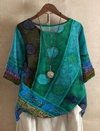 Women’s colorful floral blouse, teal with circular patch print, short sleeves.