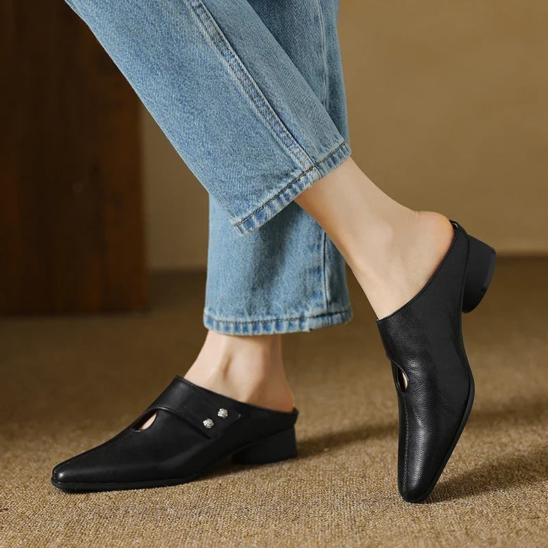 Black leather mules with pointed toe and slip-on backless design