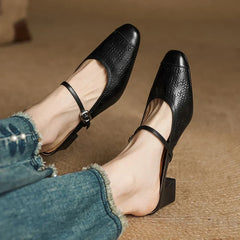 Black leather mules with buckle strap and chunky block heel, embossed texture