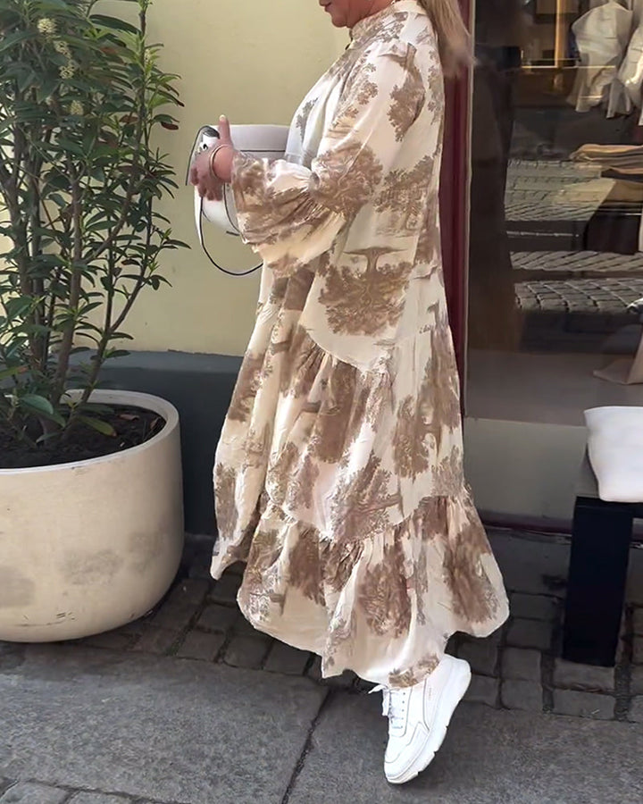 Flowing long dress in light beige with brown abstract print, tiered skirt, long sleeves.