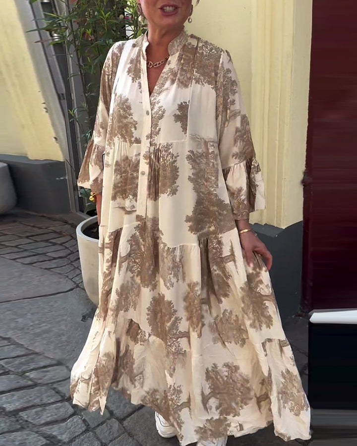 Light beige long-sleeve maxi dress with brown abstract pattern and button-front V neckline.
