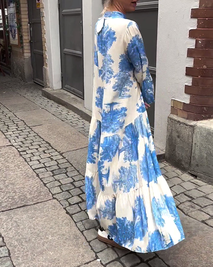 Blue and white long-sleeve maxi dress with abstract brush print and tiered skirt.