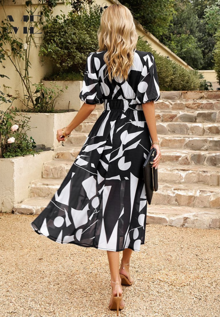 Black-and-white midi dress with puff sleeves and gathered waist; back view with flared skirt
