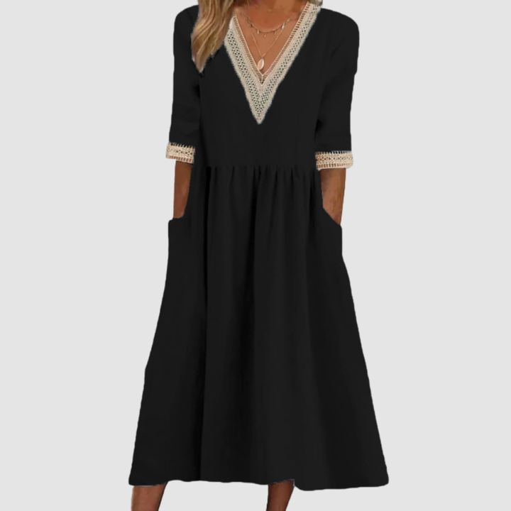 Black mid-length dress with V-neck embroidered trim, 3/4 sleeves, and tiered skirt