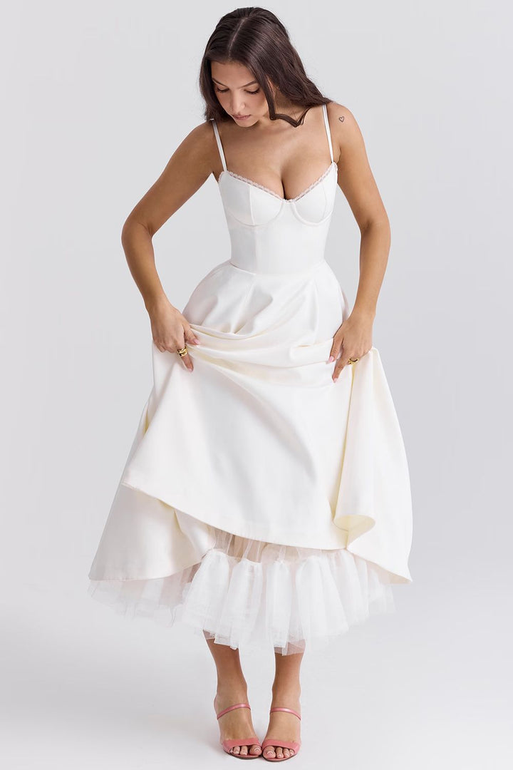 White corset-style dress with spaghetti straps, flared skirt, and tulle hem layer