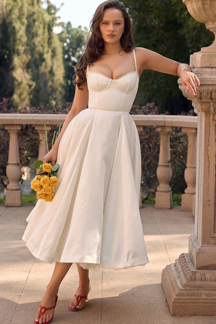 White mini dress with thin straps, sweetheart bodice, and full tulle-accent skirt
