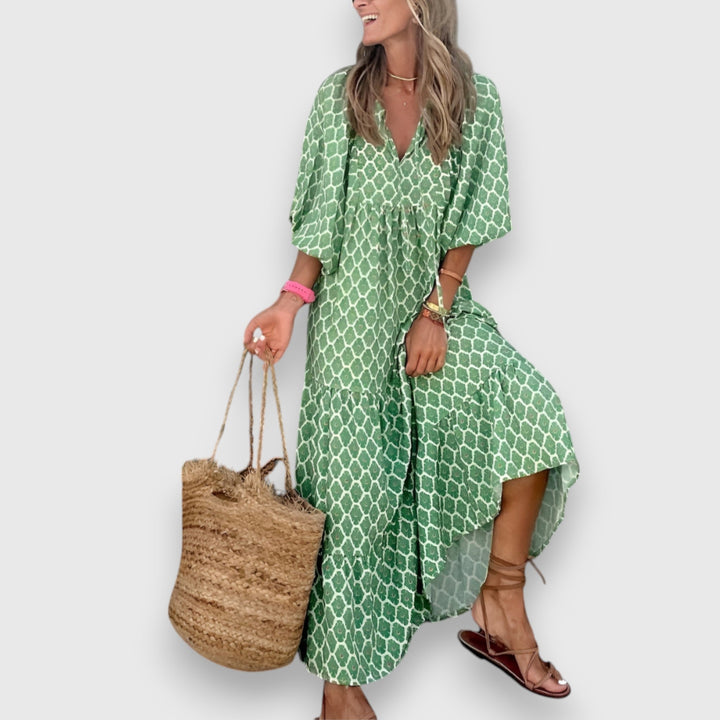 Loose breathable dress in green with white lattice pattern, V-neck and short puff sleeves.
