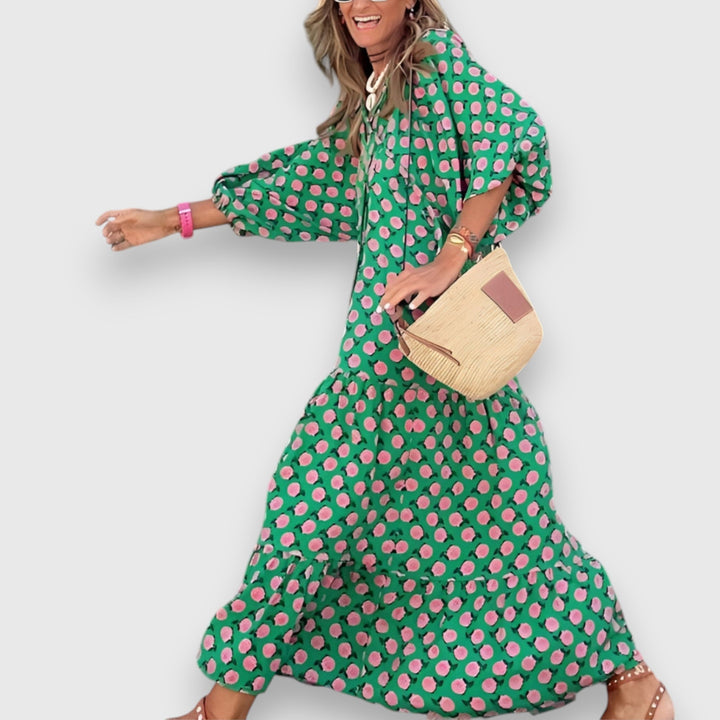Loose breathable dress, green with pink floral print, flowing tiered hem and V-neck.