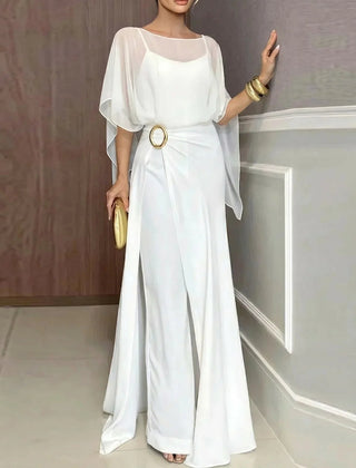 White jumpsuit set with sheer overlay poncho sleeves and ring belt detail.