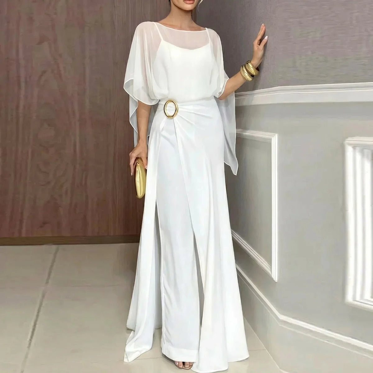 White jumpsuit set with sheer overlay poncho sleeves and ring belt detail.