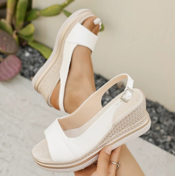 White orthopedic sandals with open toe, adjustable ankle strap buckle, textured wedge sole.