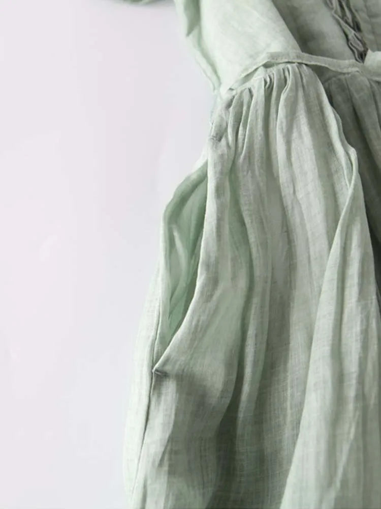 Light green linen dress with smocked ruffle neckline and gathered skirt