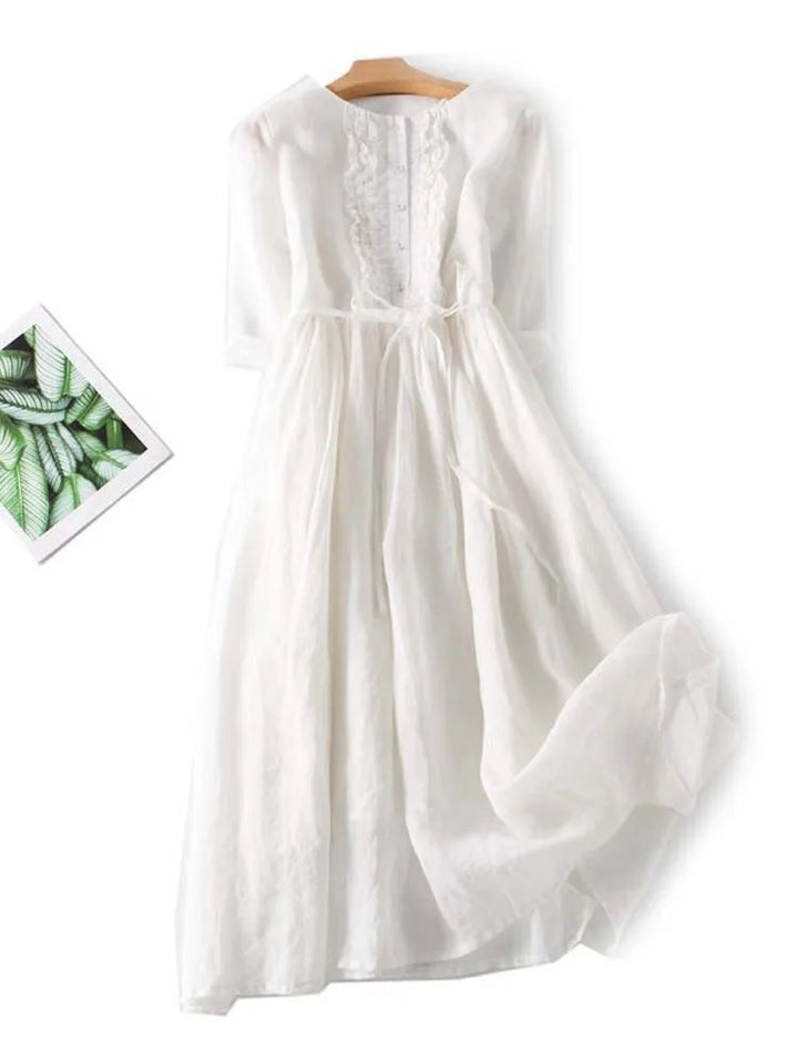 White linen dress with embroidered yoke, pleated skirt, and waist tie