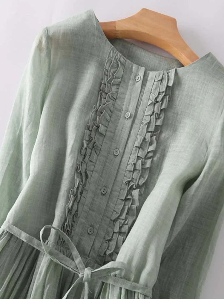 Light green linen dress front with button placket, ruffles, and waist tie