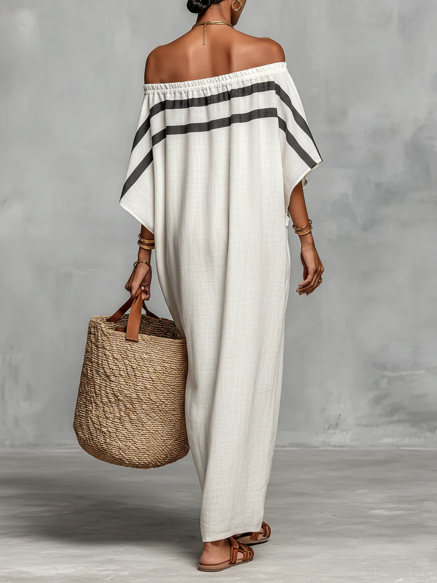 Off-shoulder white linen maxi dress with black horizontal stripe across the neckline