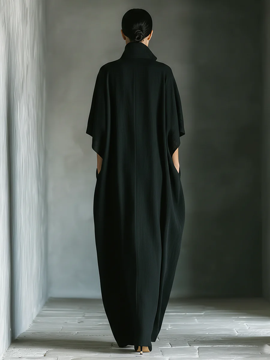 Black maxi dress back view with V-shaped yoke and wide draped shoulders