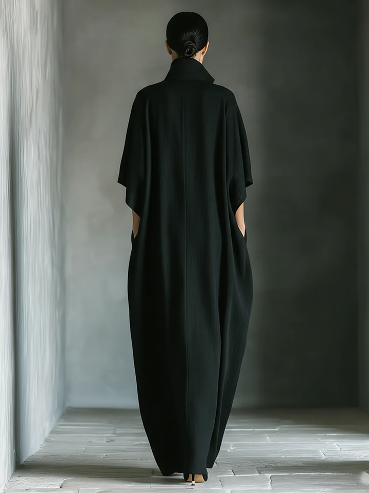 Black maxi dress back view with V-shaped yoke and wide draped shoulders