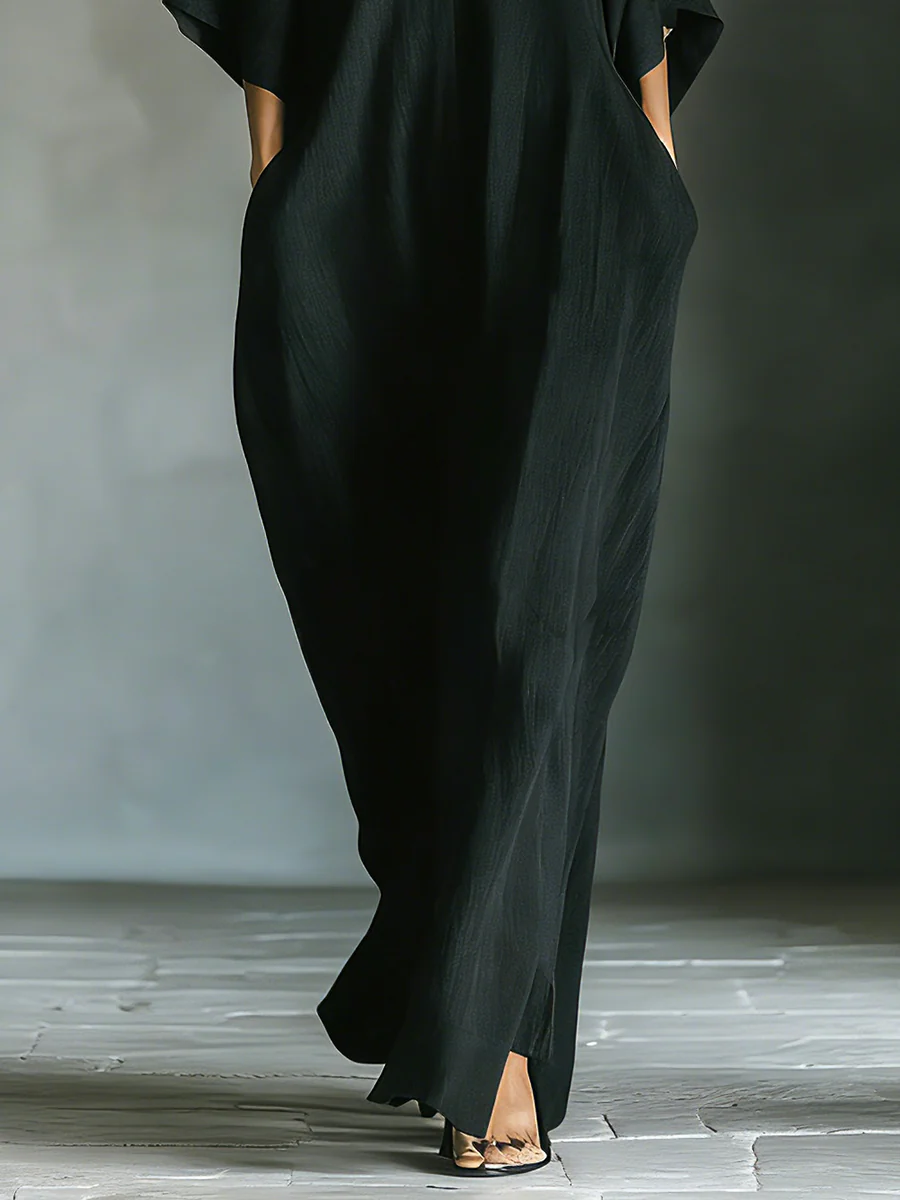 Black maxi dress front hem detail with side slit and flowing straight legs
