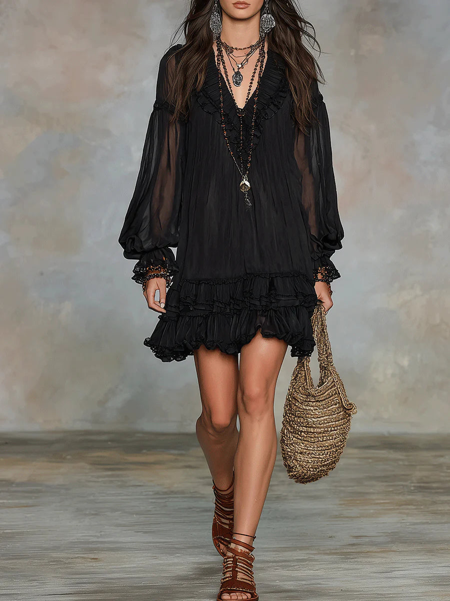 Black mini dress with V neckline, sheer sleeves, and layered ruffle trim