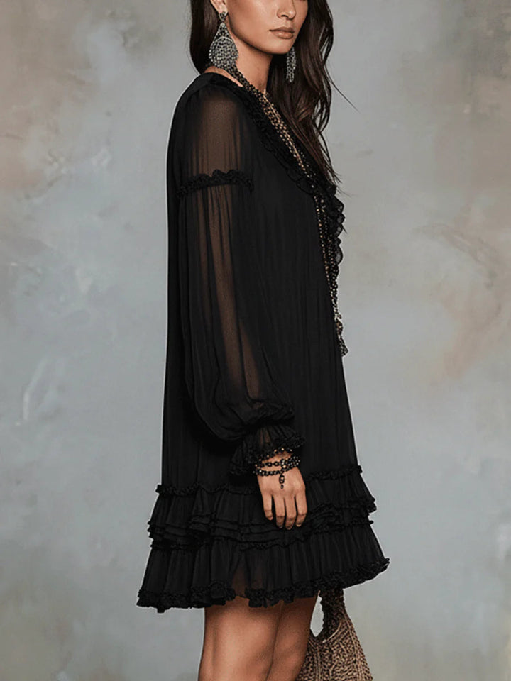 Black mini dress with sheer long sleeves and tiered ruffle skirt