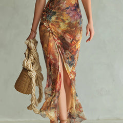Orange chiffon maxi dress with side slit and flowing ruffle hem, paint-style print