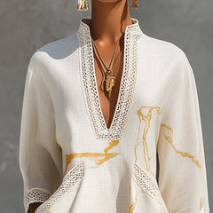 Ivory mini dress close-up: V-neck crochet lace border and gold abstract motif print