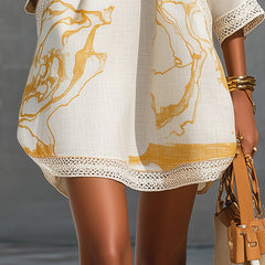 Ivory mini dress close-up: gold abstract print with crochet lace trim at hem