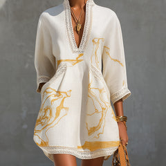 Ivory mini dress with V-neck crochet lace trim and gold abstract print, long sleeves