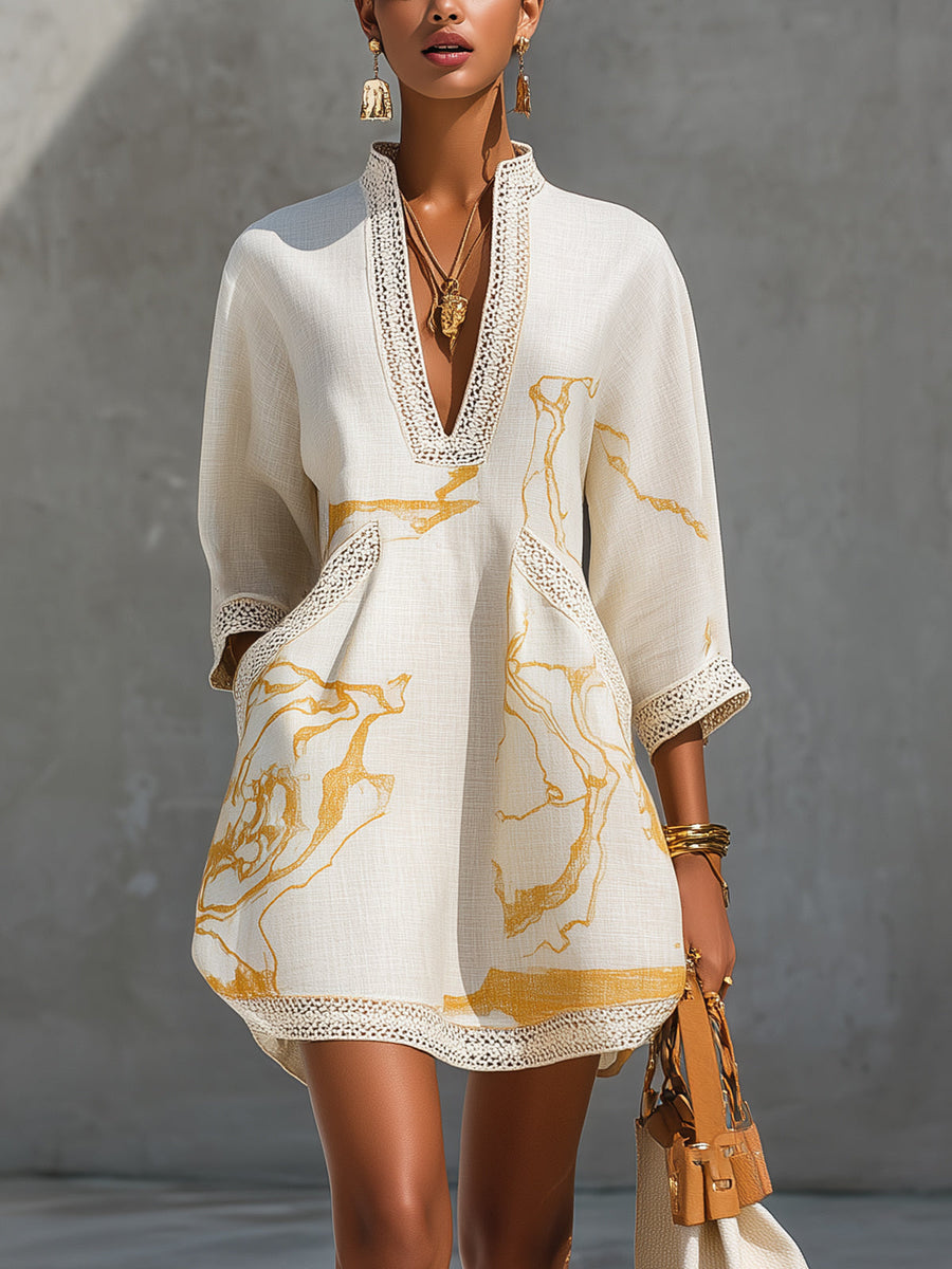 Ivory mini dress with V-neck crochet lace trim and gold abstract print, long sleeves