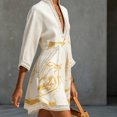 Ivory mini dress, side view: deep V neckline with crochet lace edging and gold print