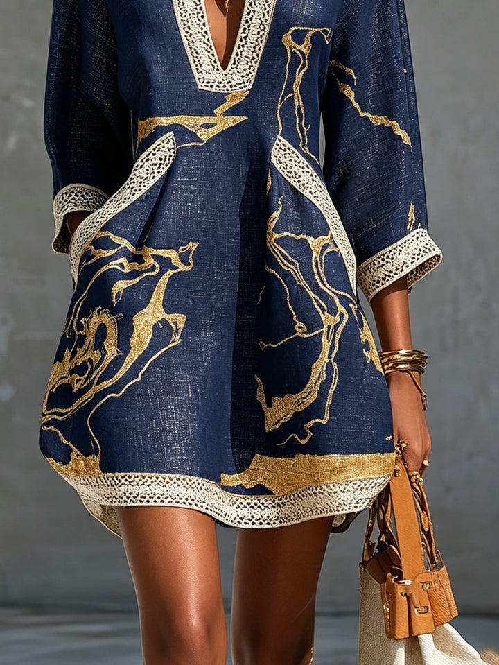 Aurelia crochet lace mini dress in navy with gold swirling print and lace border hem.