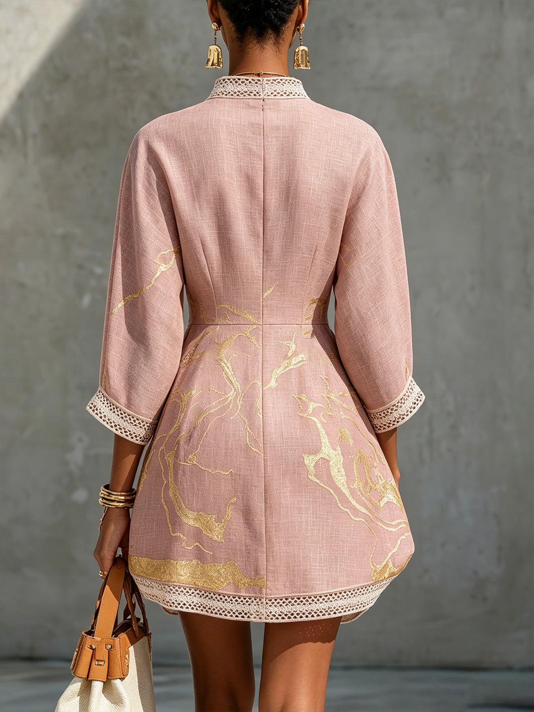 Aurelia crochet lace mini dress in pink, back view with gold motifs and lace-trimmed sleeves.
